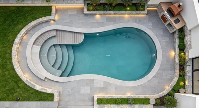Vista superior de una piscina de contorno orgánico con área de acceso escalonada